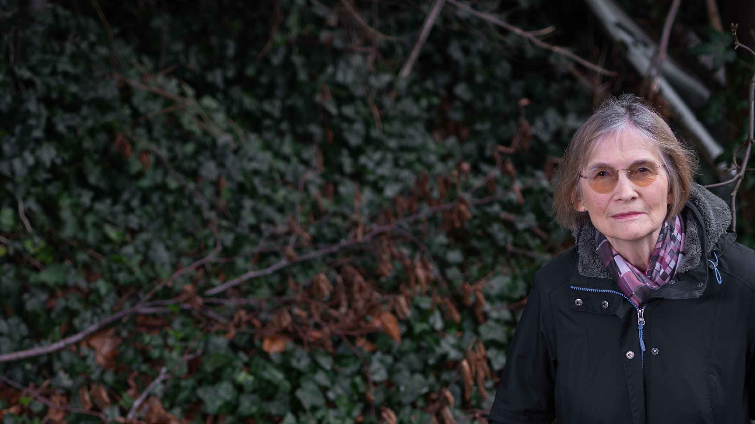 Author Danuta Reah, who has also written as Danuta Kot and Carla Banks, stands in front of undergrowth